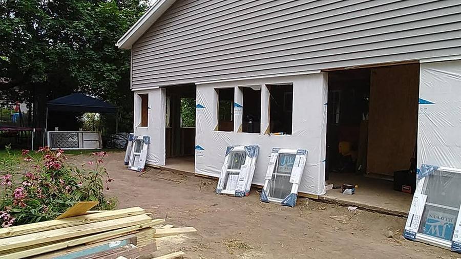 Lopez X Construction crew installing a new window during a replacement project